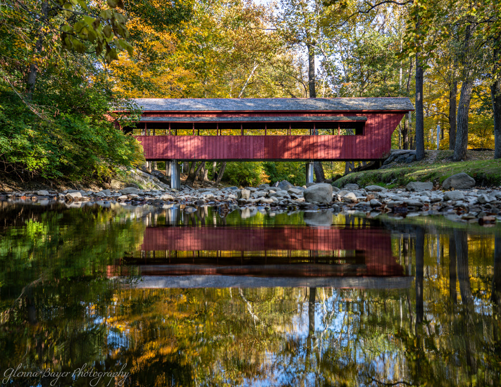 Red covered bridge and reflection in water
