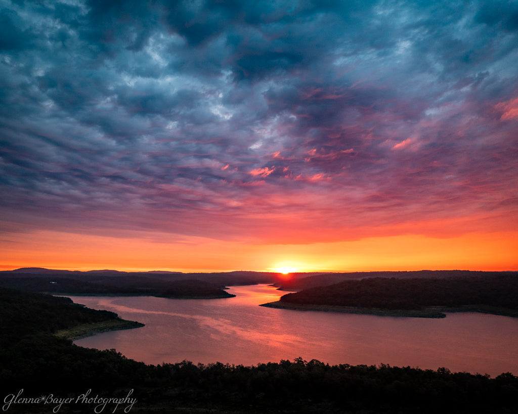 Dramatic orange, pink, and blue sunset over lake