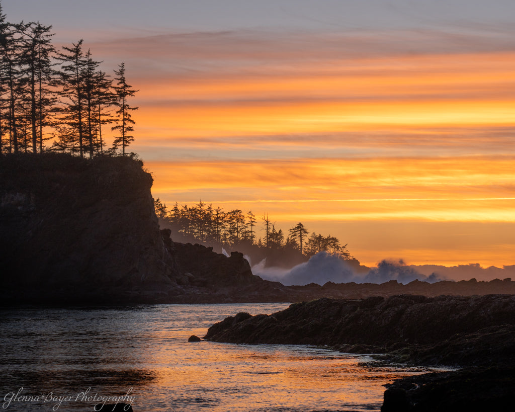 orange sunset and crashing waves on rocky coast