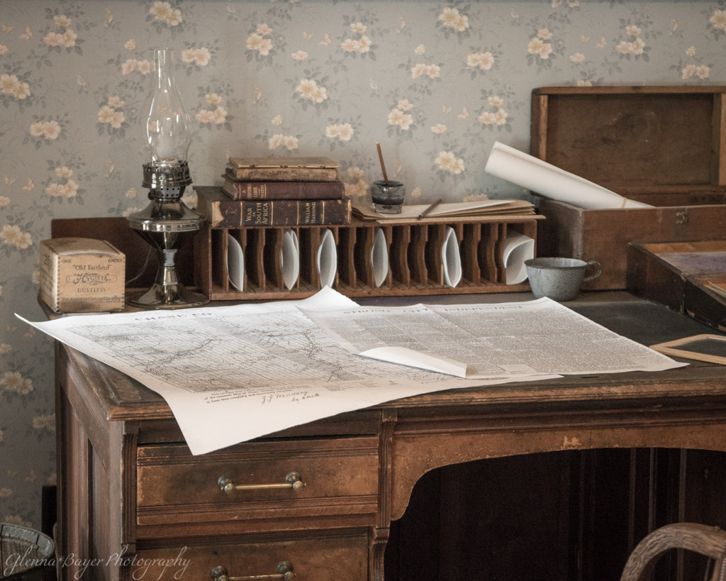 Old vintage desk with map, oil lamp, and writing quill in Flint Hills, Kansas