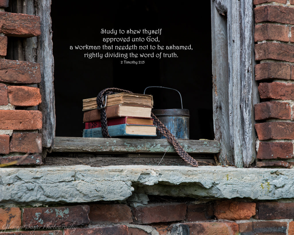 Old school books in window sill of abandon brick one room schoolhouse with scripture verse