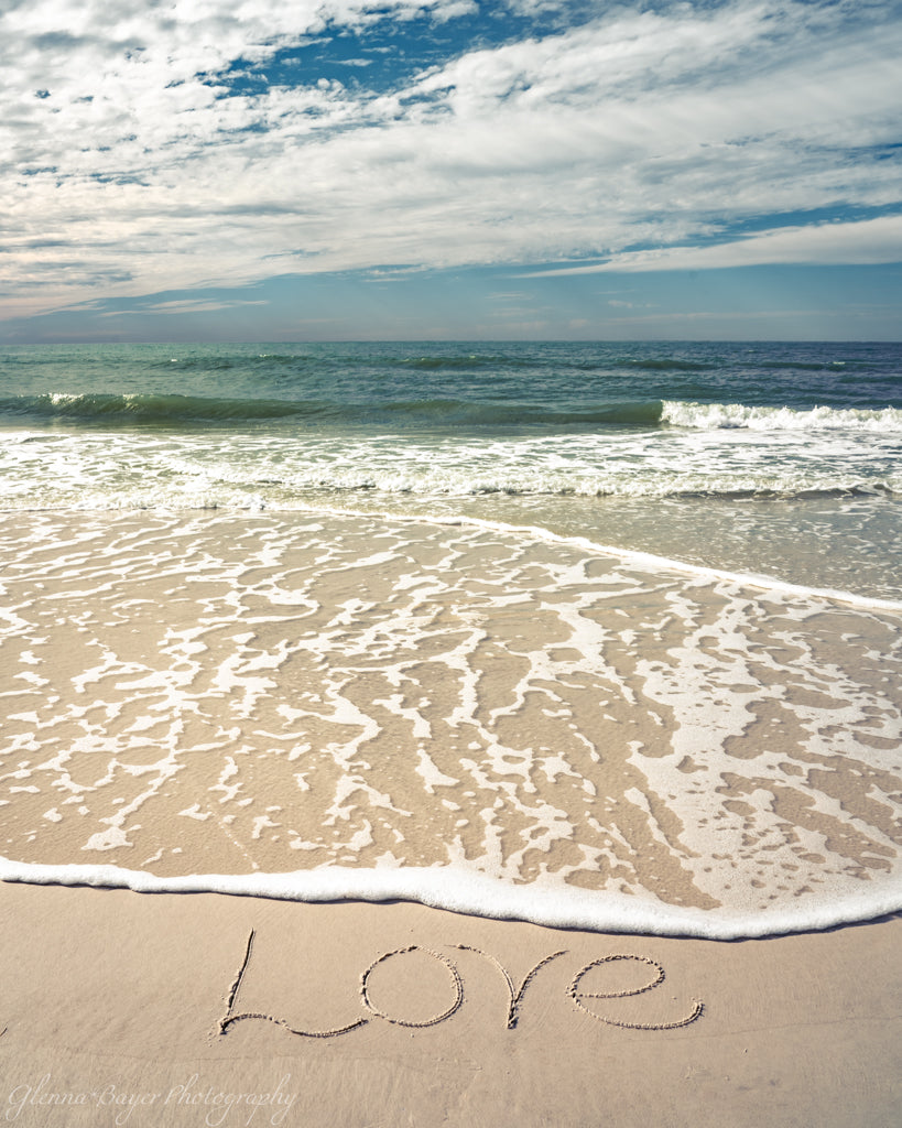 Love written in the sand at the ocean