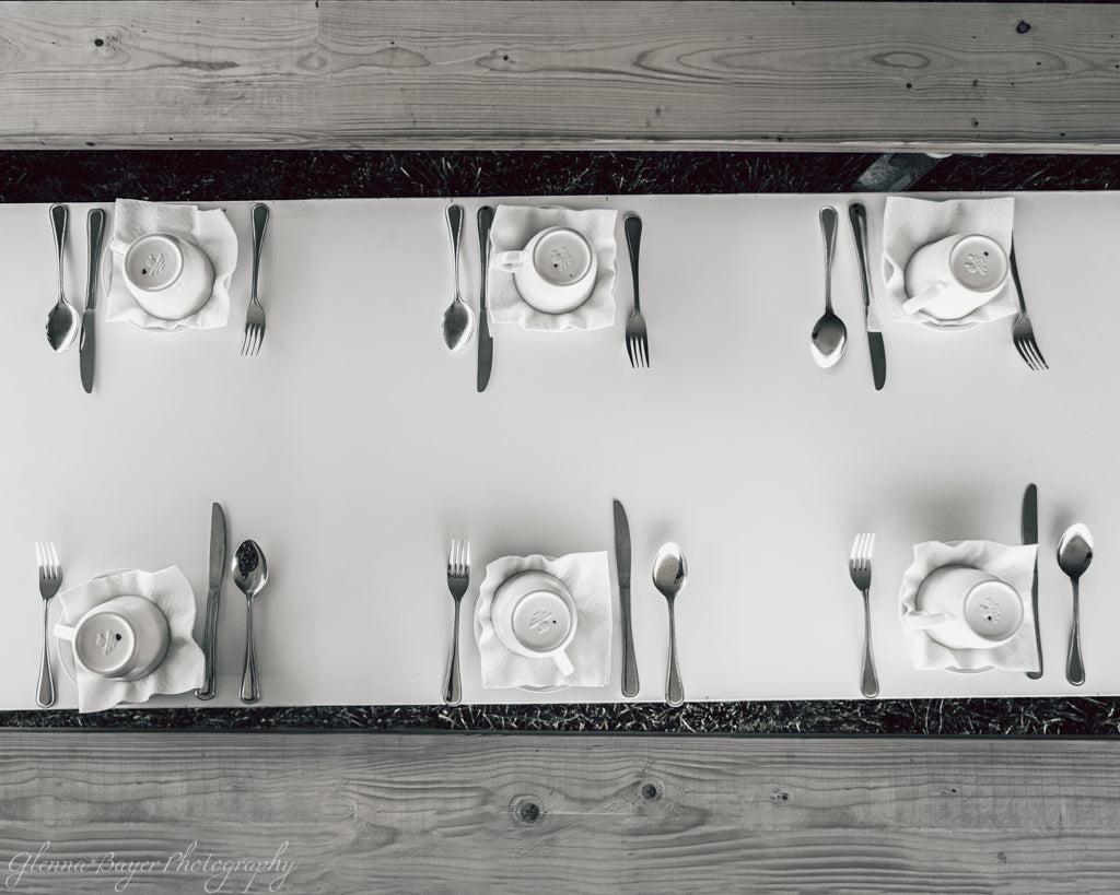overhead view of table set with cups, saucers, and silverare