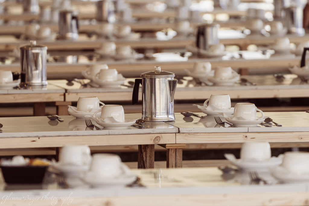 Row of tables lined with place settings and pitchers