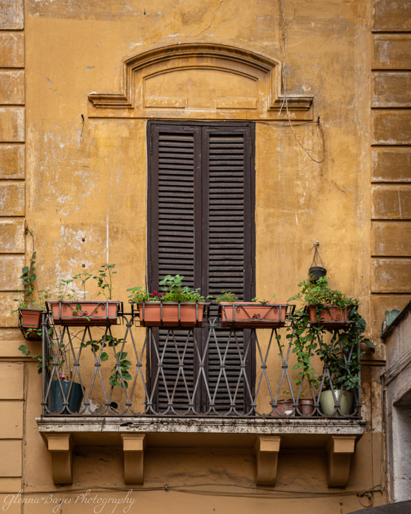 brown shuttered window on yellow building