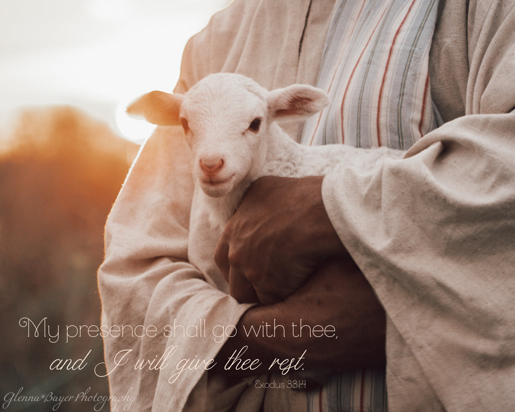 Shepherd in robe holding a lamb with a blurred background and inspirational quote.