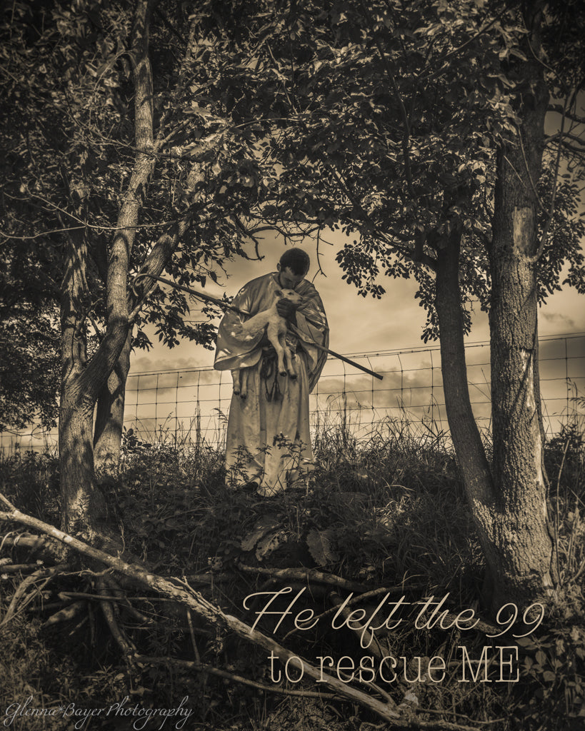 Sepia photo of shepherd holding a lamb and staff between two trees with a fence in the background.