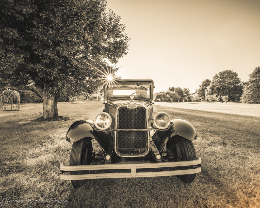 Vintage 1928 Chevy AB National car parked on grass with trees in the background