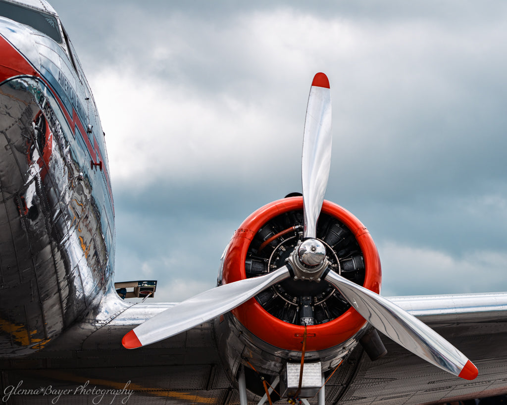 Close-up of a vintage airplane propeller against a cloudy sky.