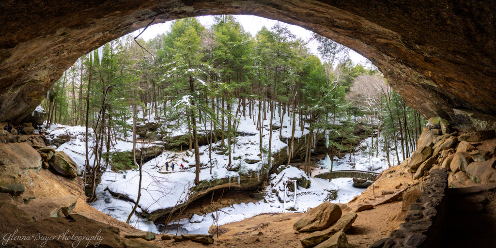 View from inside a cave looking out onto a snowy forest landscape
