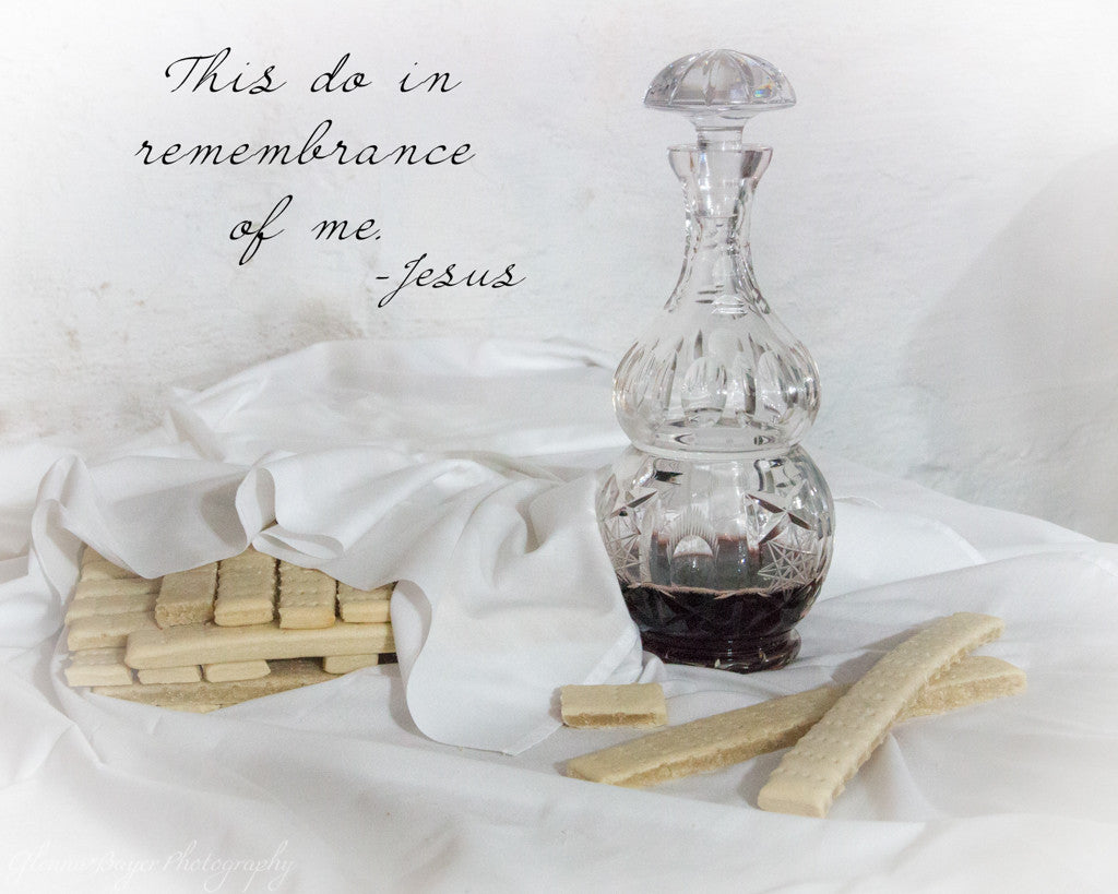 Unleavened communion bread under white linen cloth and wine in crystal decanter, with scripture verse