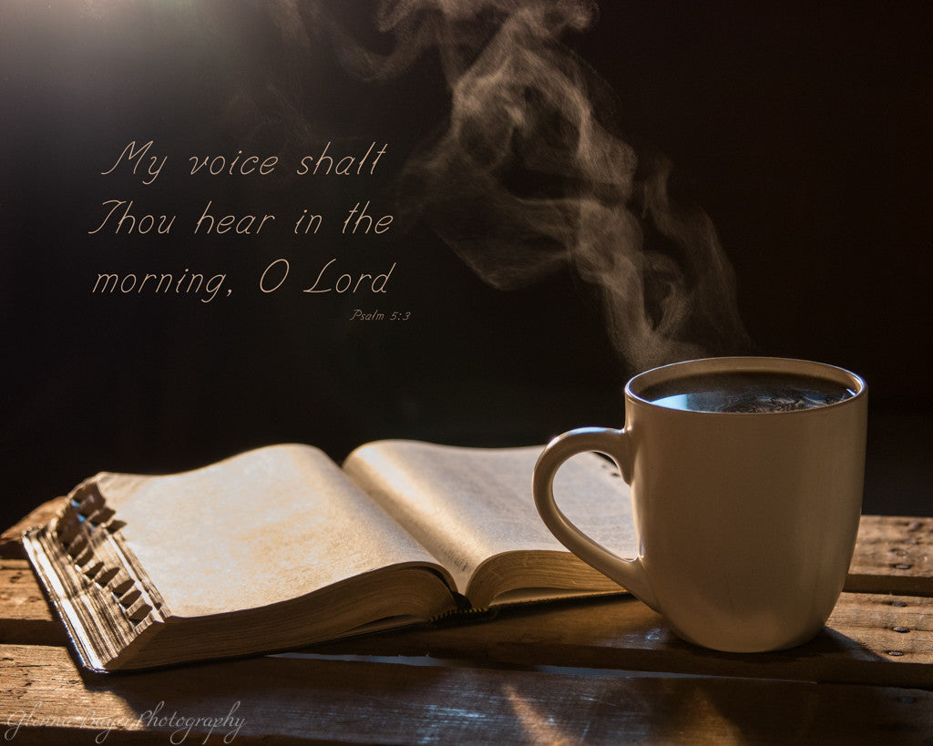 Steaming cup of coffee beside open Bible with scripture verse