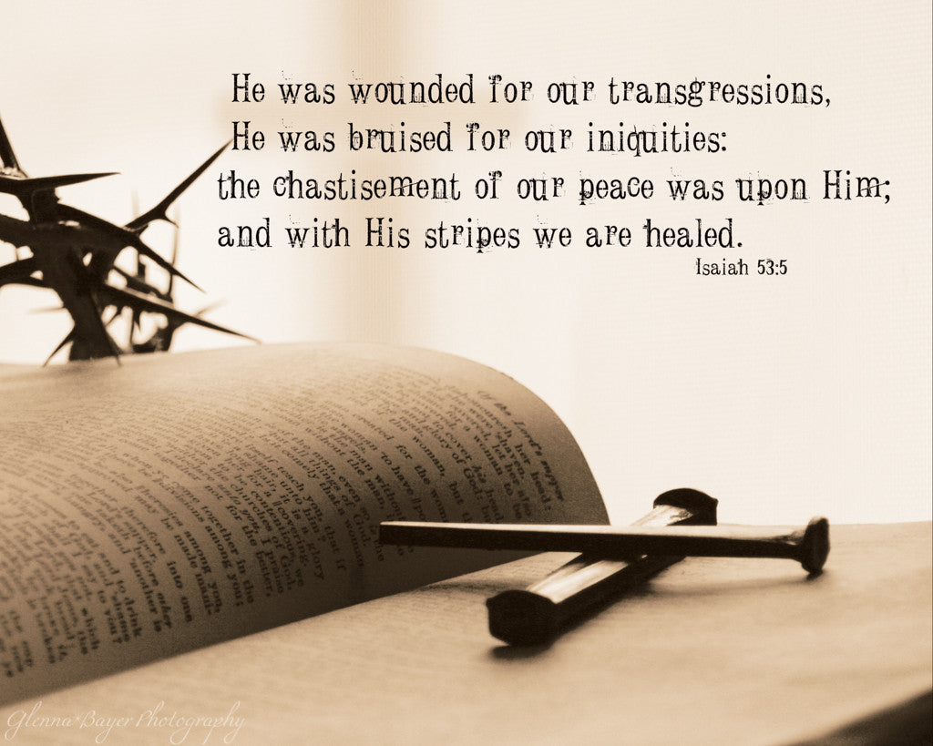 Crown of thorns and nails lying on open Bible with scripture verse