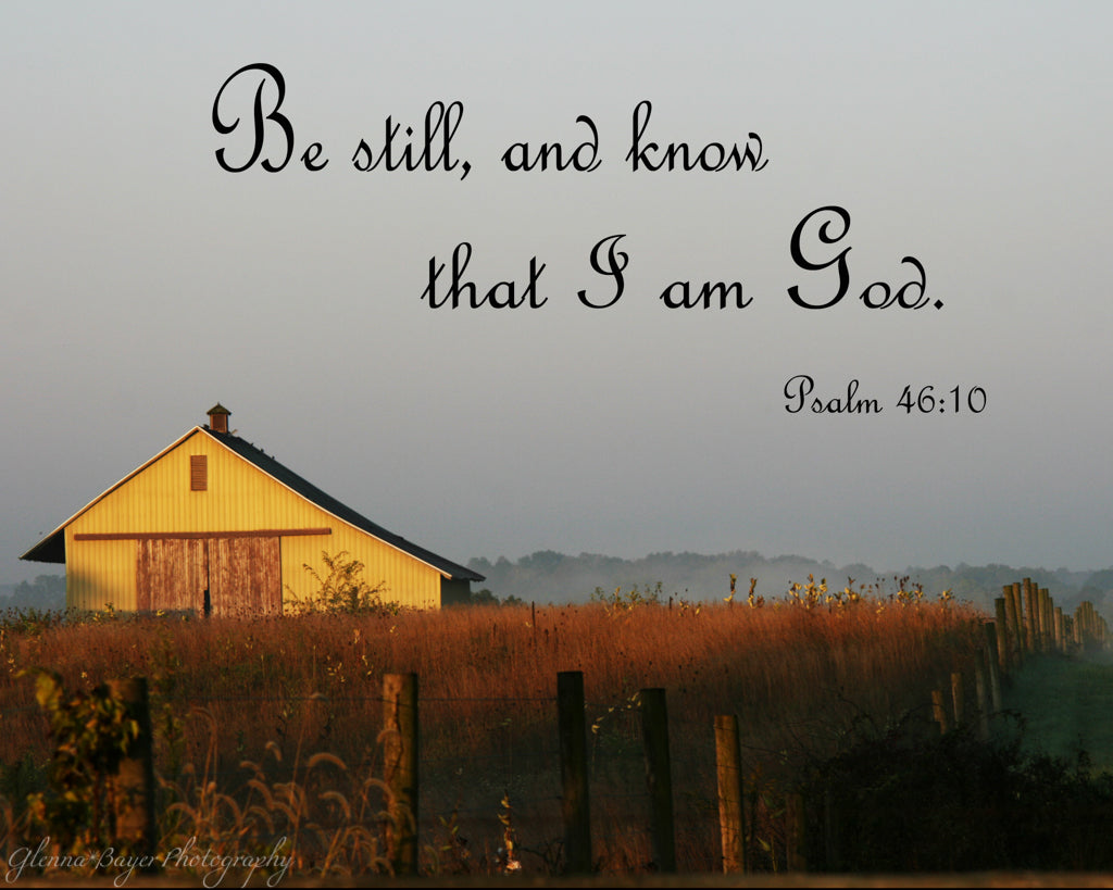 Old sunlit barn in field with scripture verse