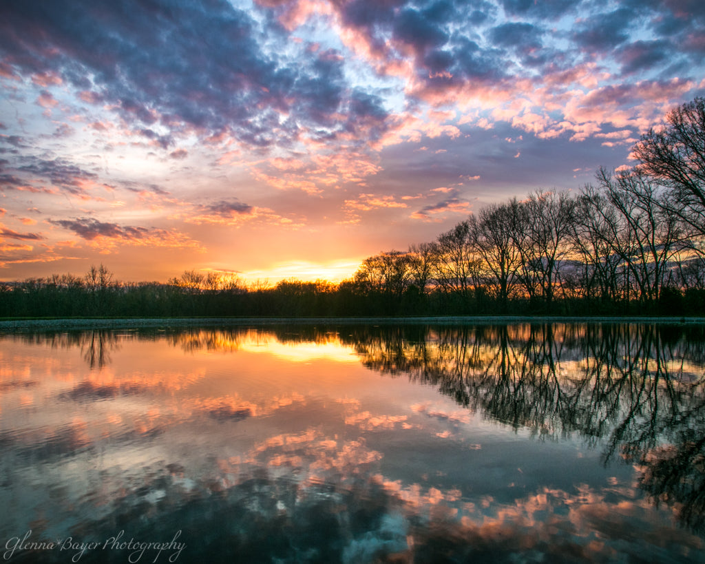 Dramatic colorful sunset and reflection over pond