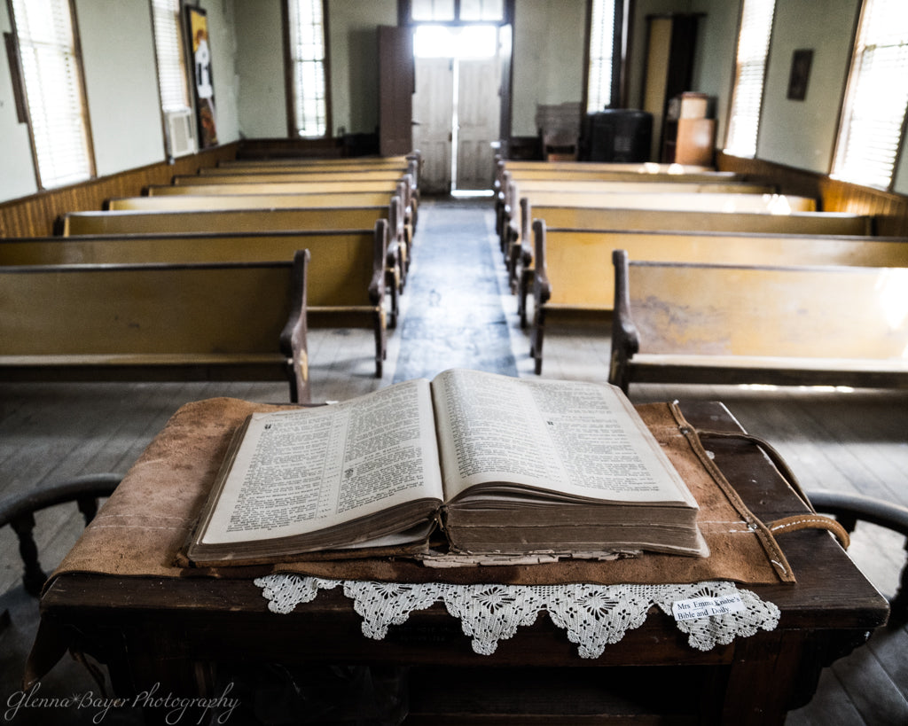 Old church with wooden pews and an open bible on the pulpit