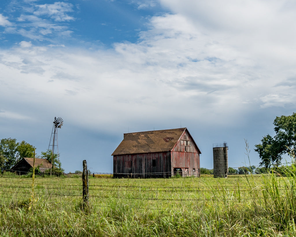 Old farm with wood barns and windmill during summer time in Kansas