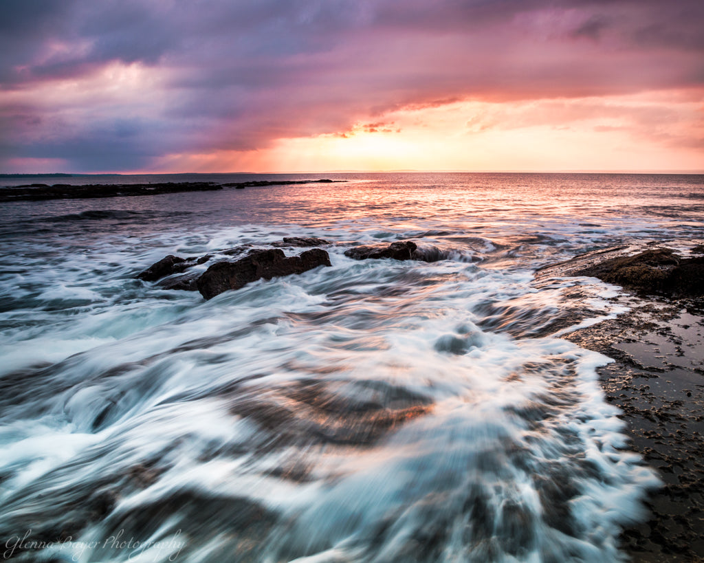Sunrise over Jervis Bay and waves crashing over rocks in Australia