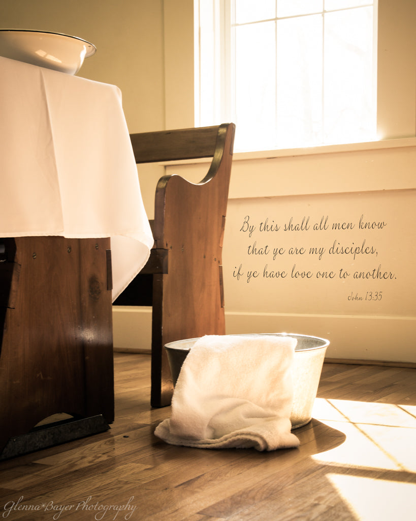 Footwashing tub and towel beside church bench with scripture verse