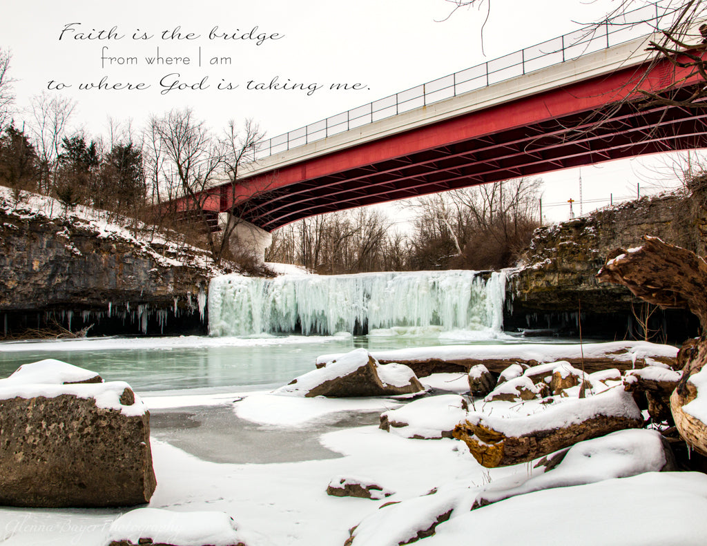 Red bridge over frozen water fall with quote