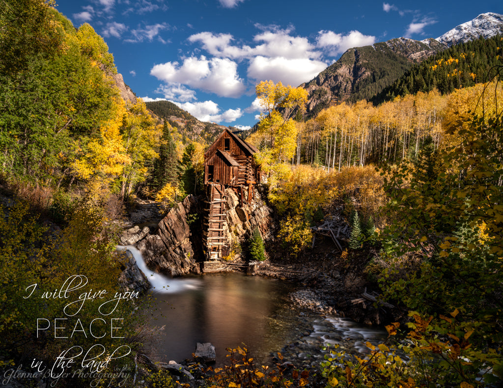 Mill beside stream in mountains during autumn with bible verse