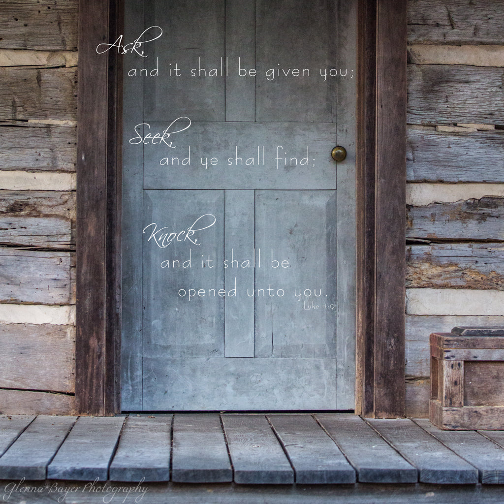 Old log cabin's gray door with scripture verse