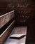 Old Bible lying on wooden bench with scripture verse.