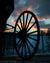 Silhouette of Amish buggy wheel during sunset