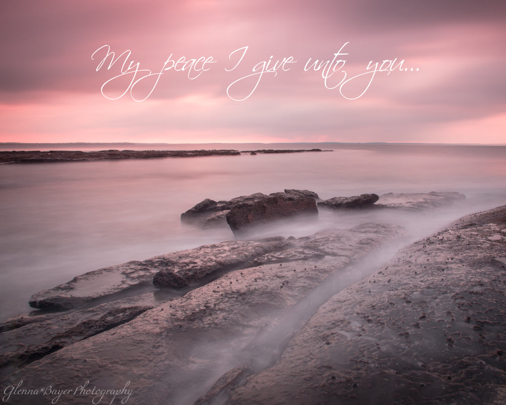 Pink sunrise and ocean flowing over rocks in Jervis Bay, Australia with scripture verse