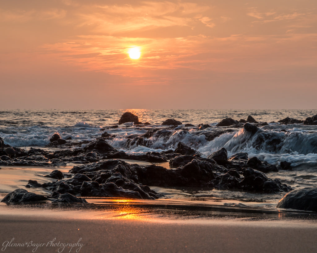 Orange sunset over ocean and beach in Hawaii