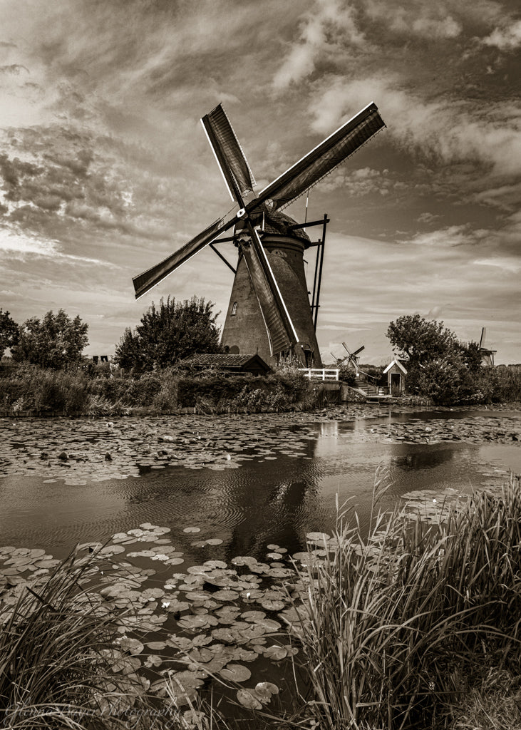 Holland windmill by canal in sepia