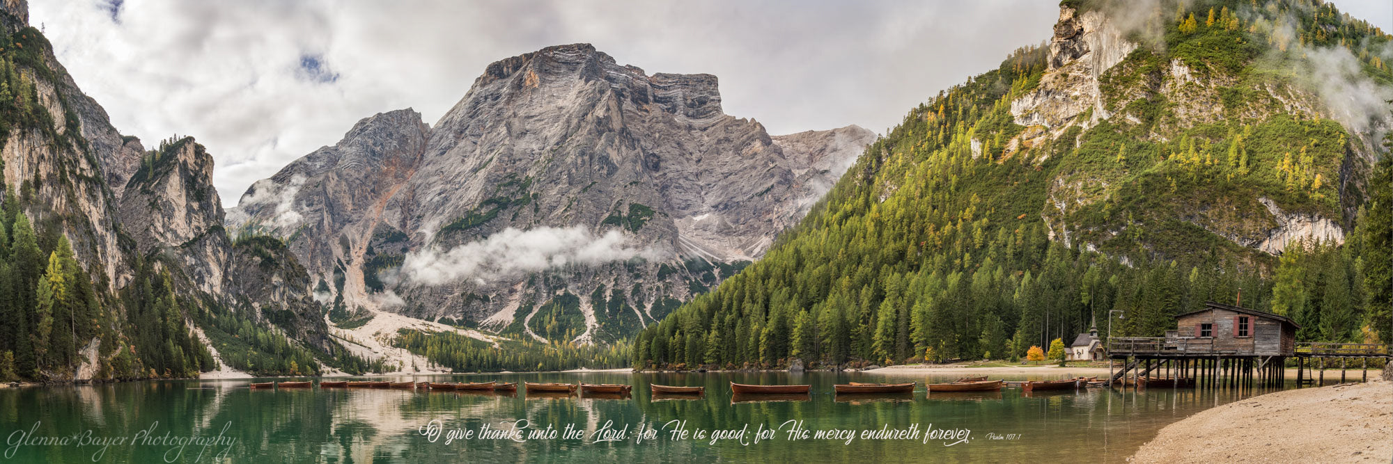Panorama of canoes lined across Lake Braise in Dolomites, Italy with scripture verse