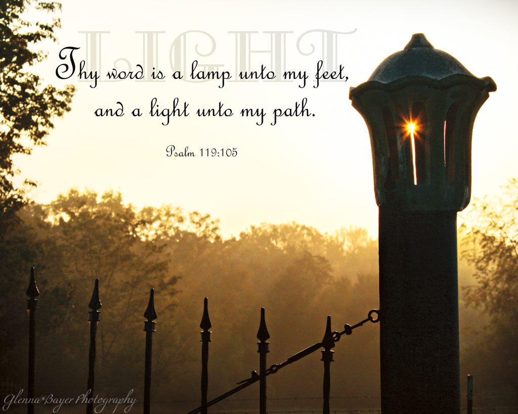 Silhouette of lamp post with sunburst in orange foggy morning light with scripture verse