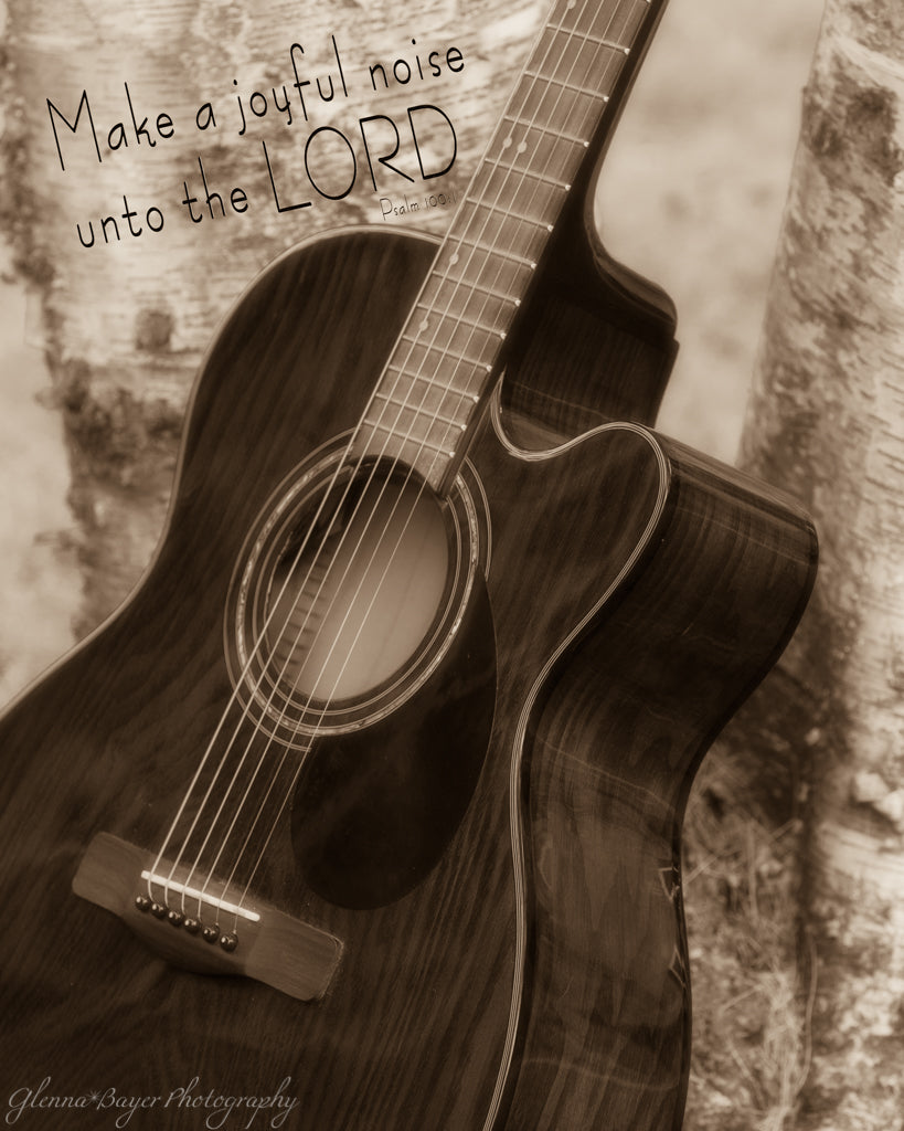 Acoustic guitar leaning against tree with scripture verse