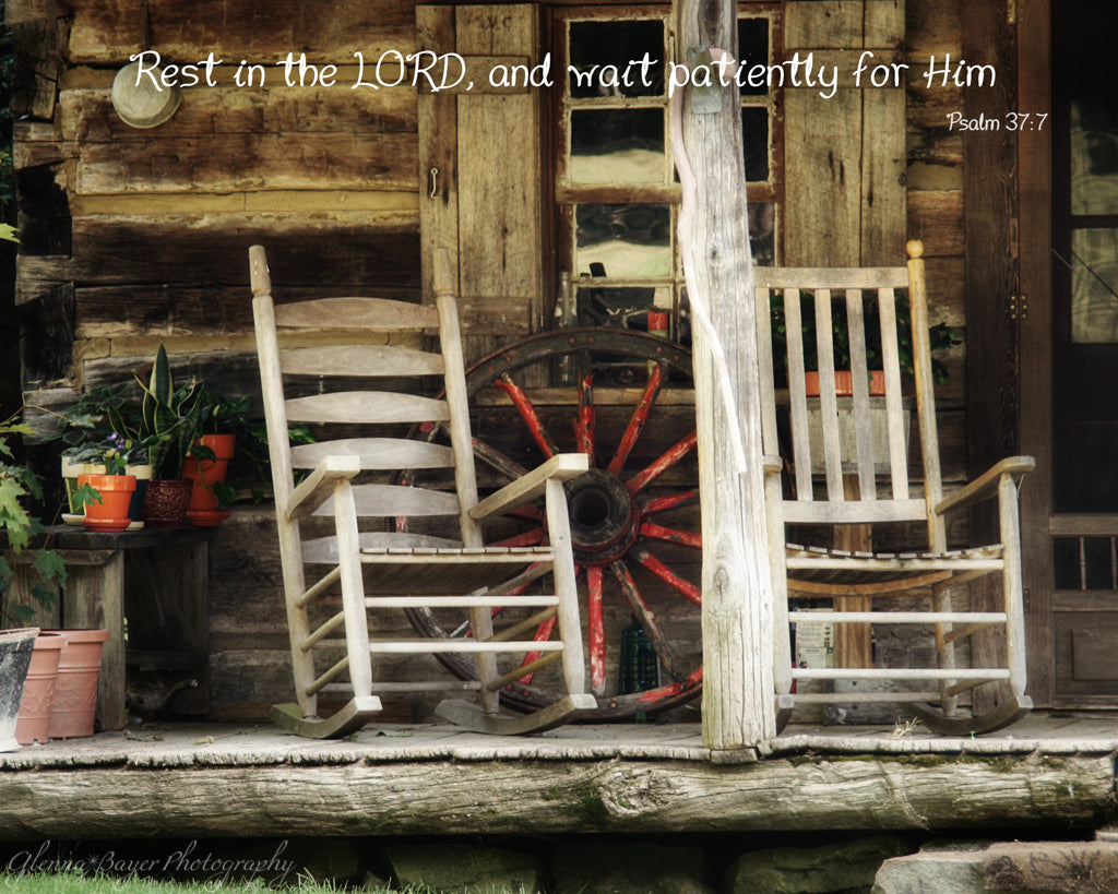 Old wooden rockers on front porch of log cabin with scripture verse