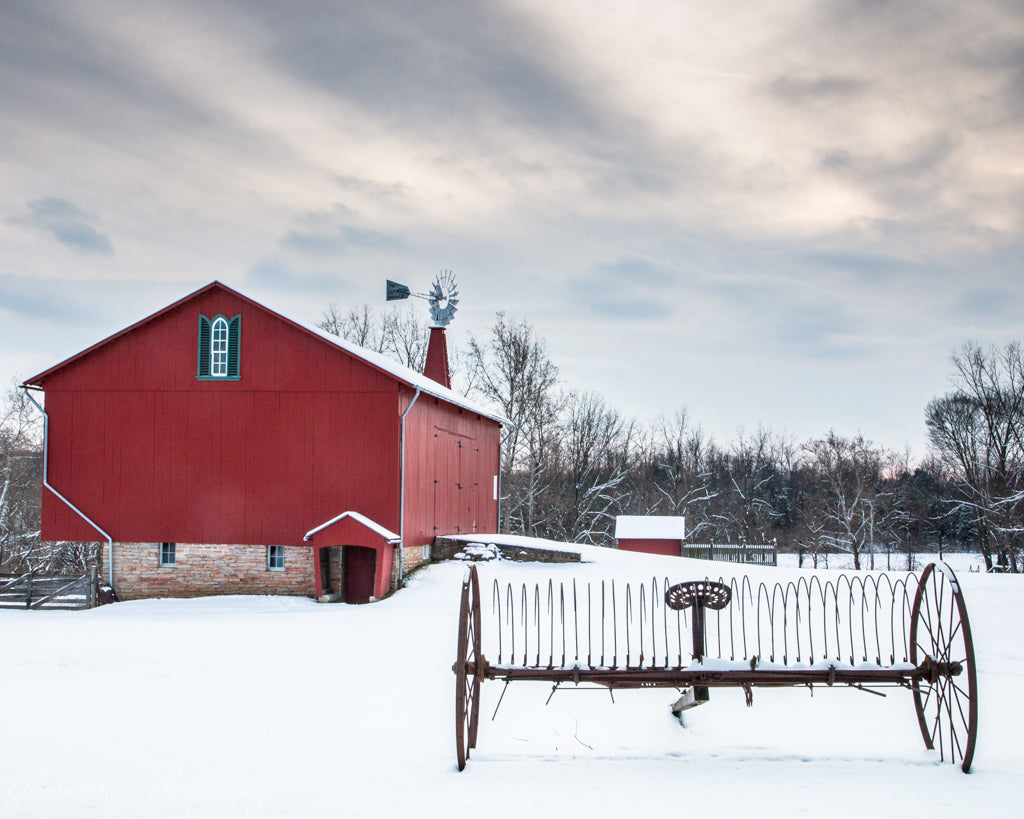 Farming rake and red barn in snow at Carriage Hill Metro Park, Ohio